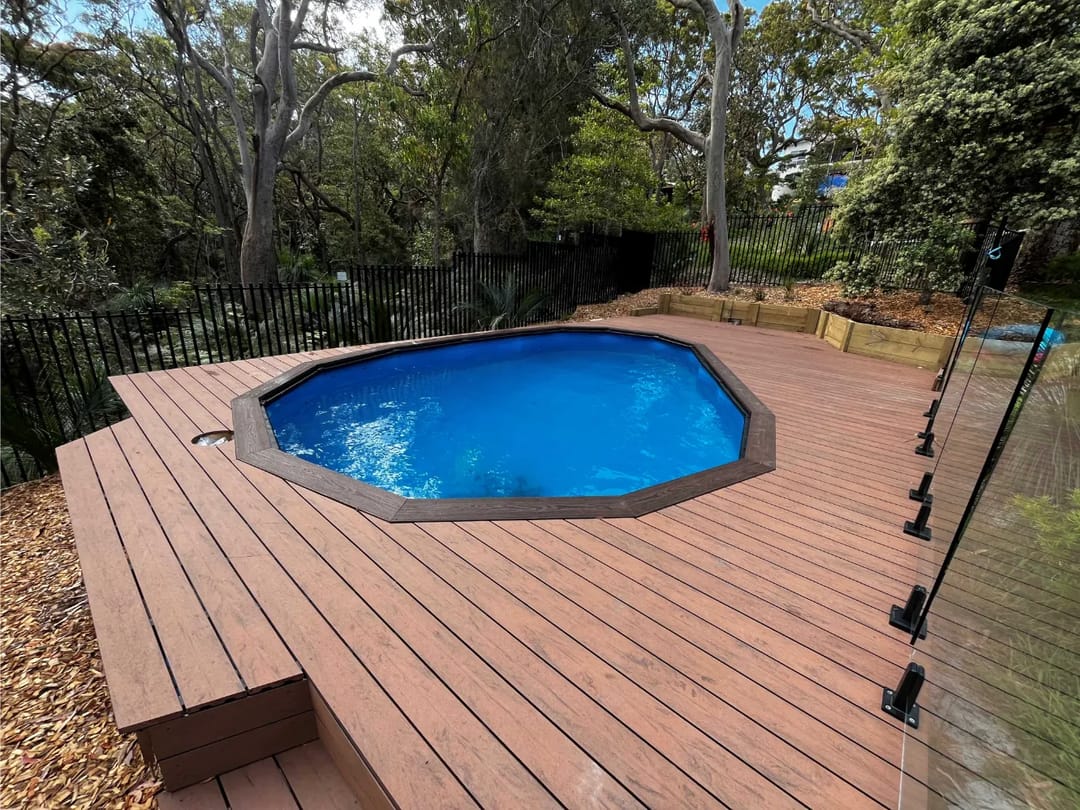 Raised deck in CleverDeck Eco-Pro Black Bean around an octagonal above-ground pool in a bush garden