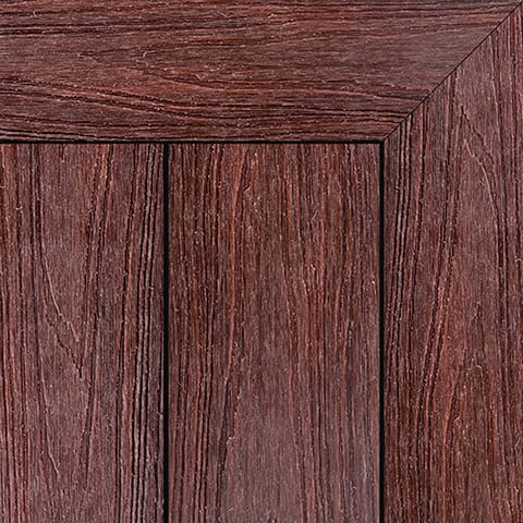 Close-up of Brite HD PRO composite deck boards in Merbau, a deep red-brown woodgrain, with a mitred picture-frame corner
