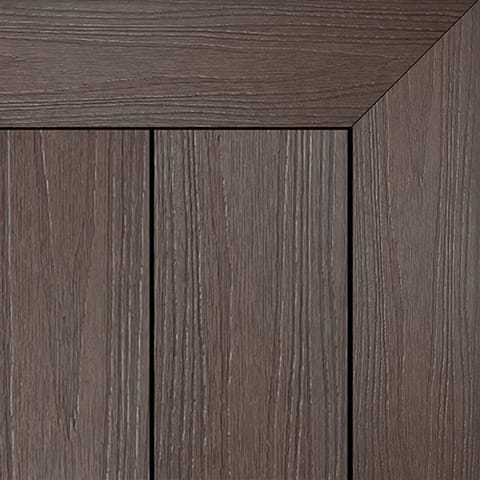 Close-up of Brite HD PRO composite deck boards in Black Walnut, a dark chocolate woodgrain, with a mitred picture-frame corner