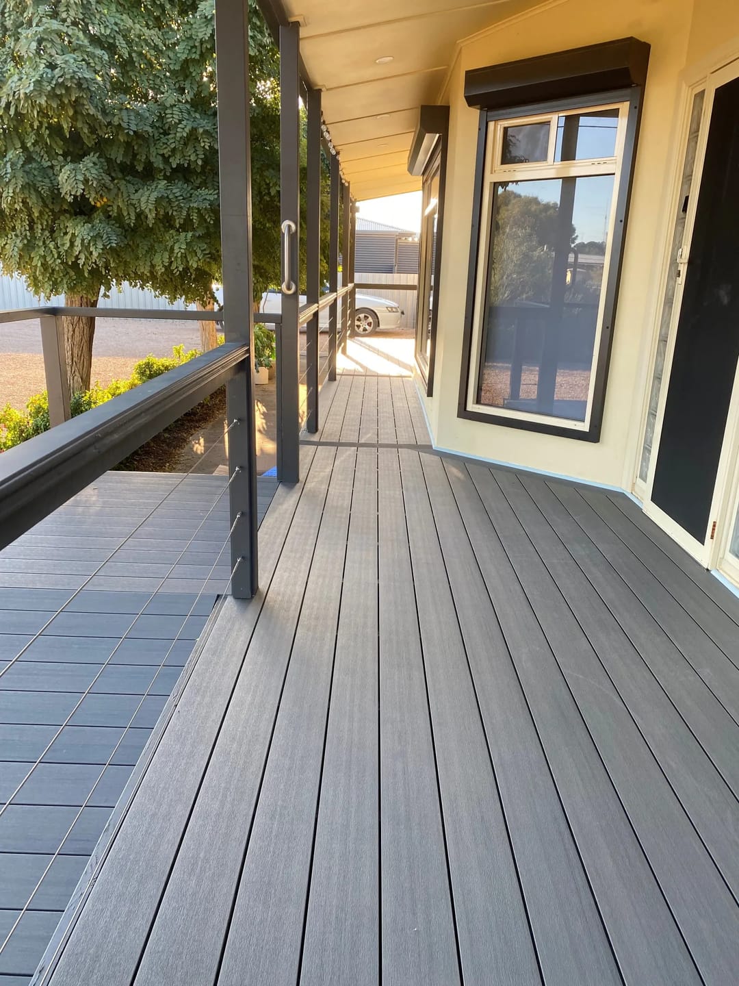 Front verandah decked in CleverDeck Xtreme Basalt 138 mm boards along a weatherboard house with black posts and railings
