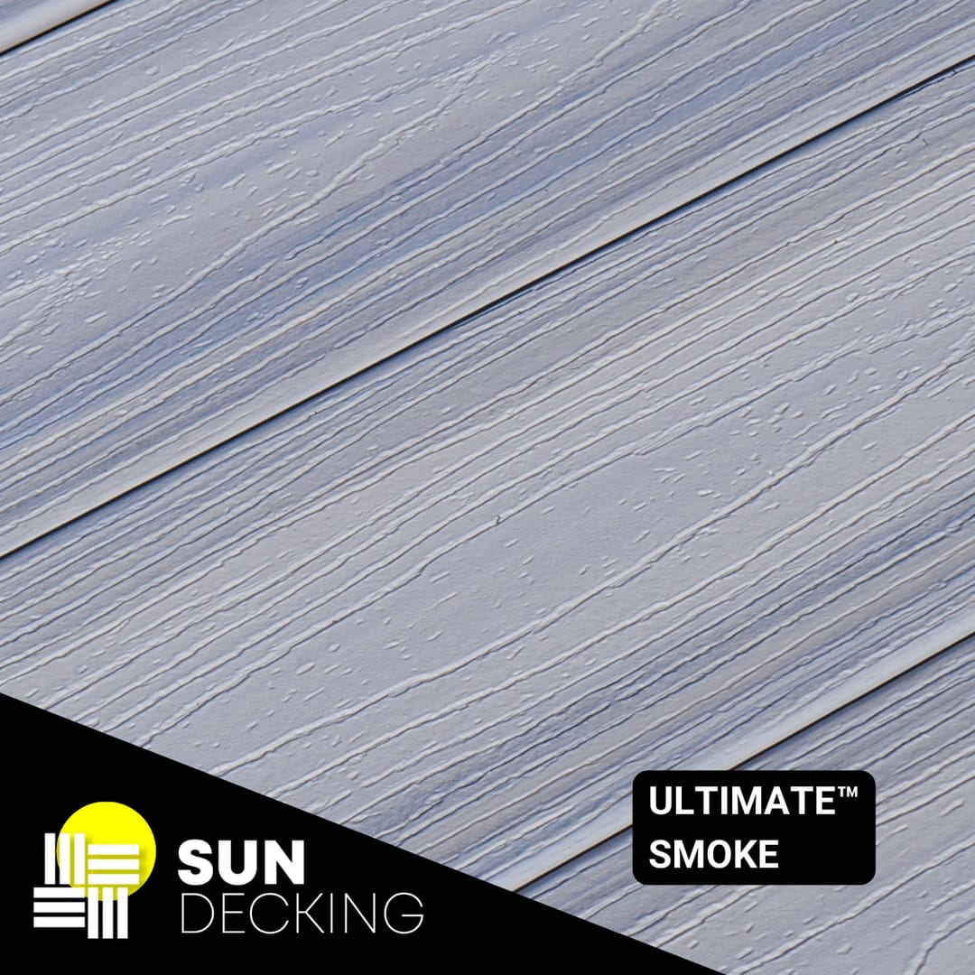 Angled close-up of Sun Decking Ultimate composite boards in Smoke, a streaked grey woodgrain, with the Sun Decking logo