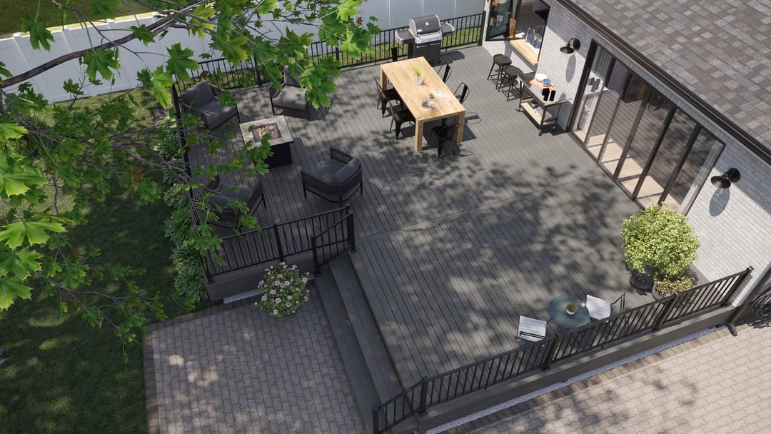 Computer-rendered aerial view of a grey Millstone deck with dining table, lounge and black railing beside a paved yard
