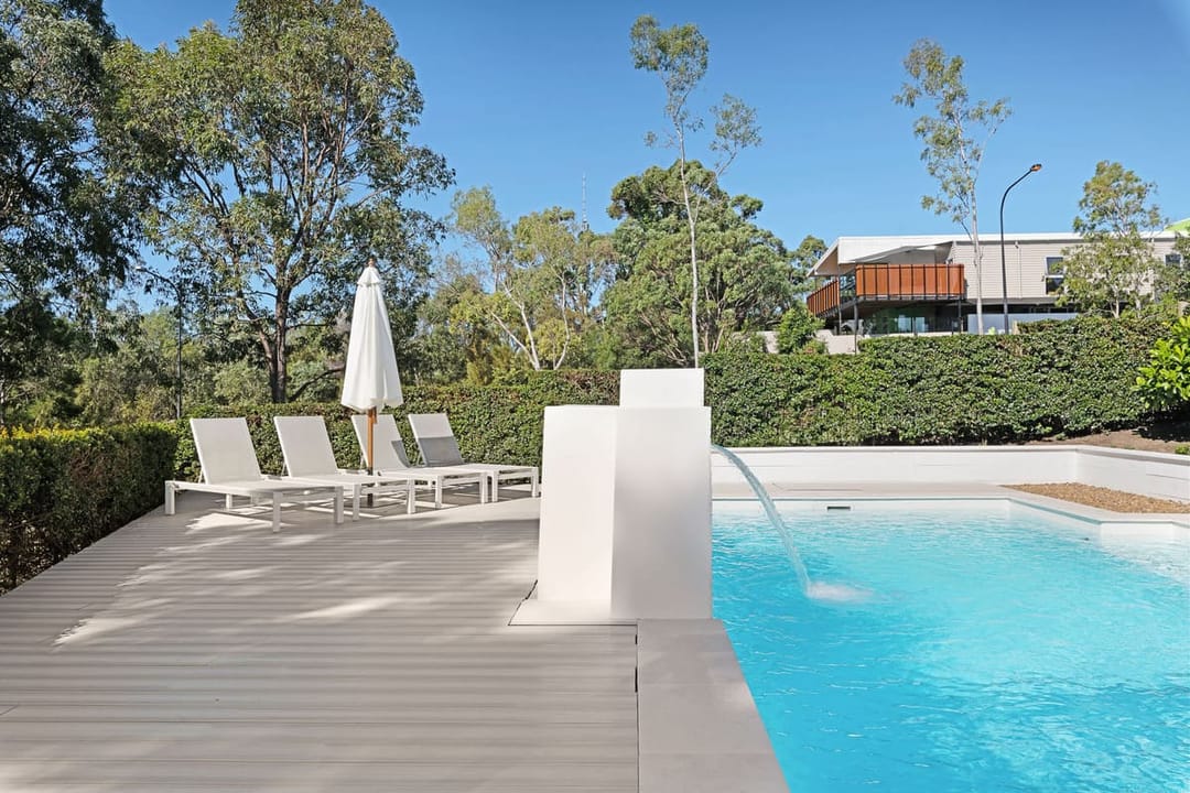 Pale Brite HD Urban X pool deck in Reedy Creek QLD with white sun loungers, an umbrella and a pool water spout