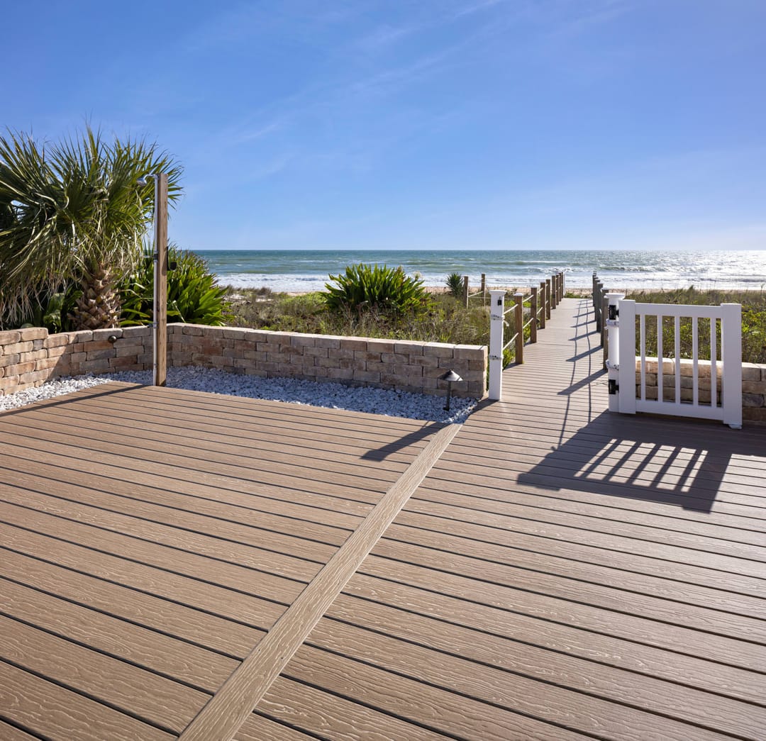 Light brown Mochaccino deck with a contrasting border board, leading to a white gate and a beach path