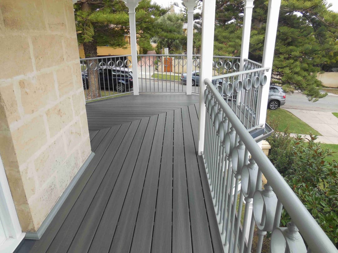 Grey Slate verandah deck wrapping a limestone house behind a white lace-pattern balustrade