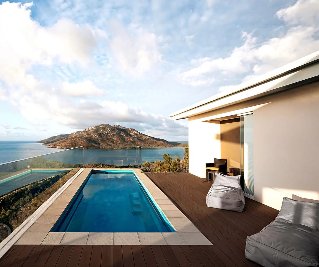 Ekodeck Classic Dark Brown deck around a lap pool with bean bags, overlooking the sea and an island