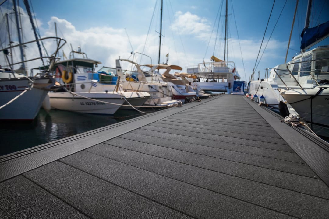 Ekodeck Maxiboard marina walkway between moored yachts and motor boats under a blue sky