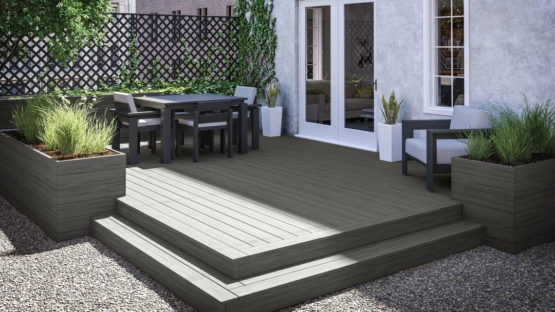 Small two-step Riviera deck with planter boxes and an outdoor dining set in a gravel courtyard with a trellis wall