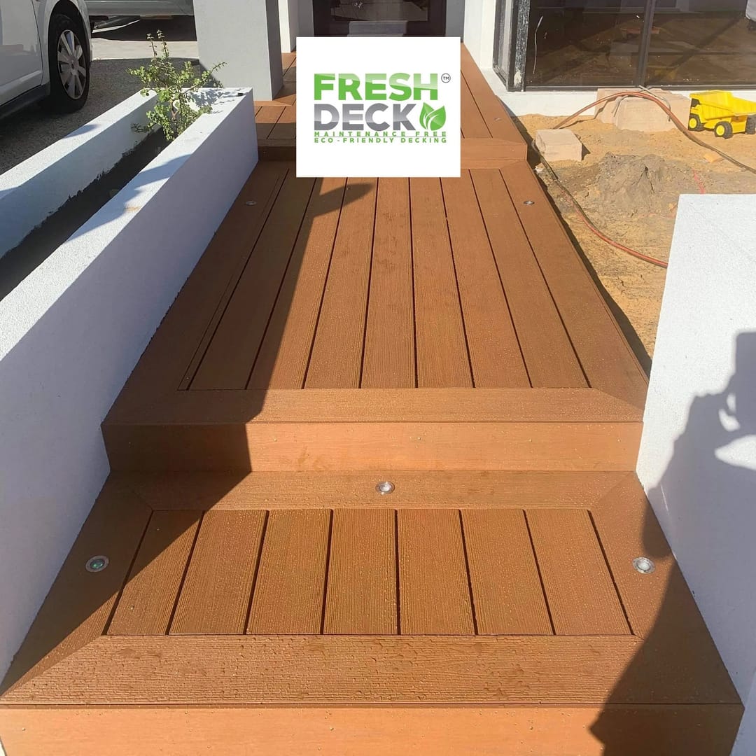 Orange-brown FreshDeck composite steps and landing with step lights between rendered garden walls