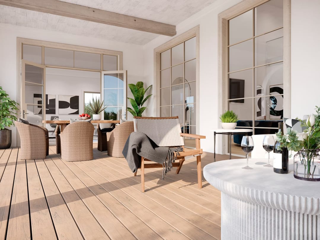 Light beige Lineage Carmel decking on a covered patio with wicker chairs, a round table and glass doors into the house