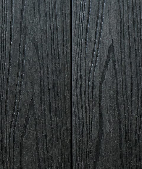 Two Modern Deck Classic Solid boards in Charcoal, a near-black woodgrain-embossed composite surface shown close up