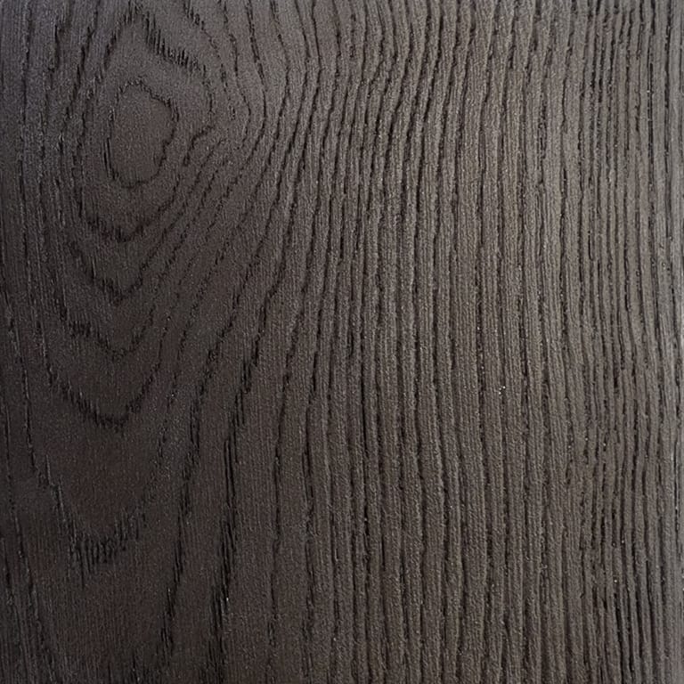 Full-frame close-up of an INNODECK board in Aged Oak, a dark grey-brown surface with deep embossed oak grain