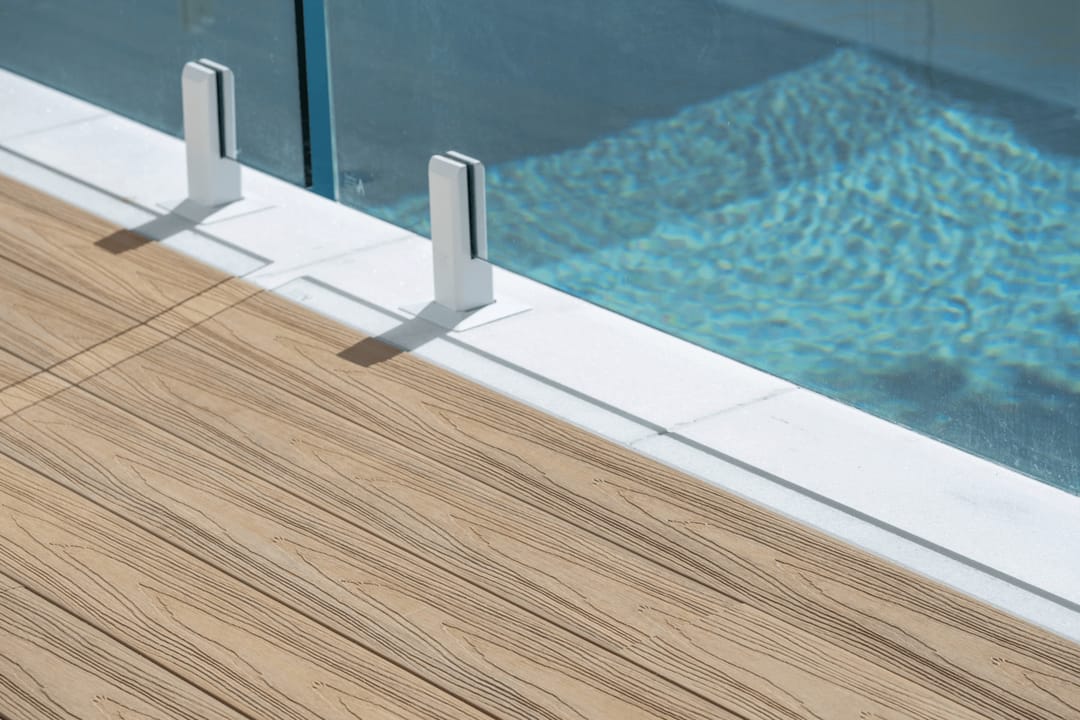 Colour visualisation of COEN Beach, a light warm timber tone, as decking boards meeting a pool edge with glass fence spigots