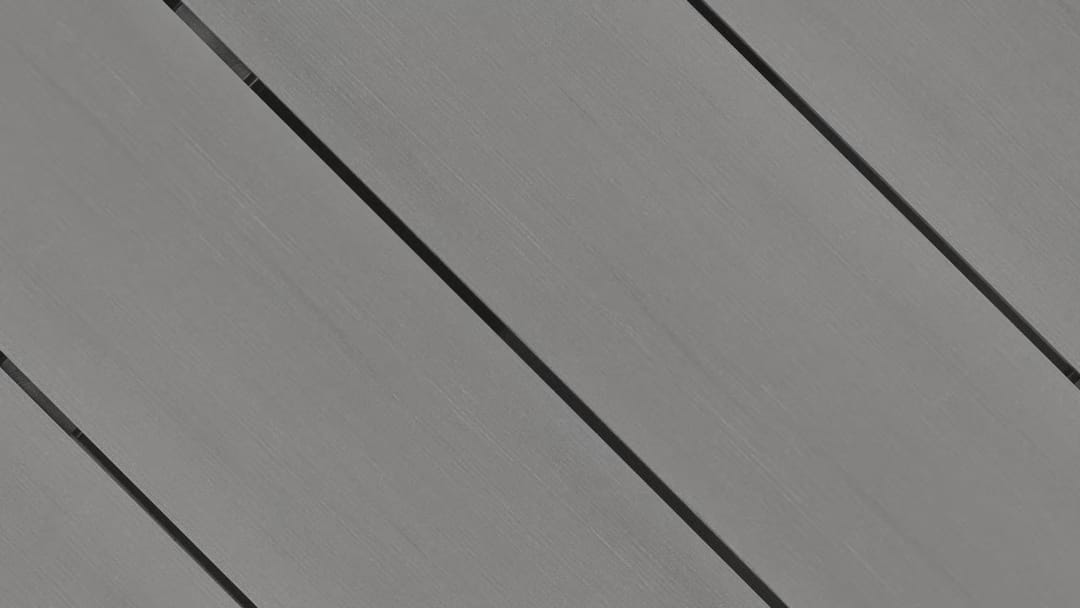 Close-up of Outdure CasaDeck Ash Pure composite deck boards laid on the diagonal, in even mid grey