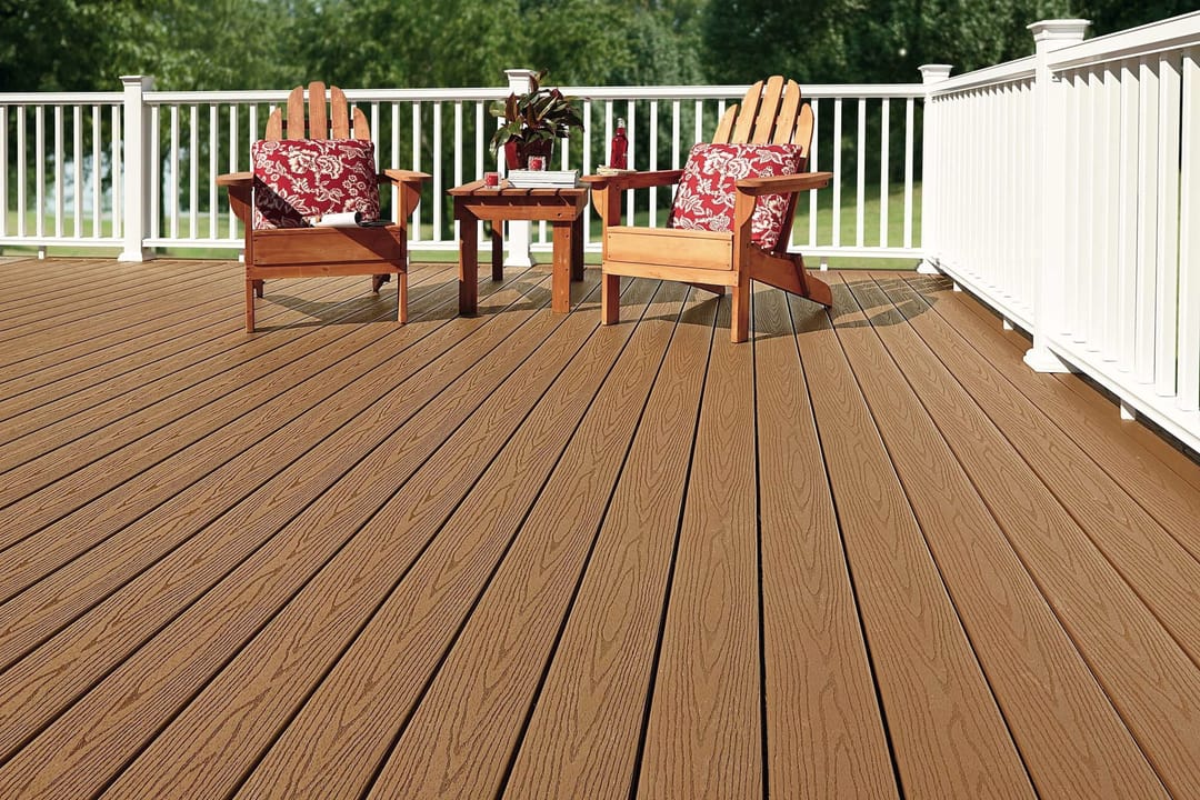 Brown Cabin deck with two Adirondack chairs, red cushions and a side table behind a white railing