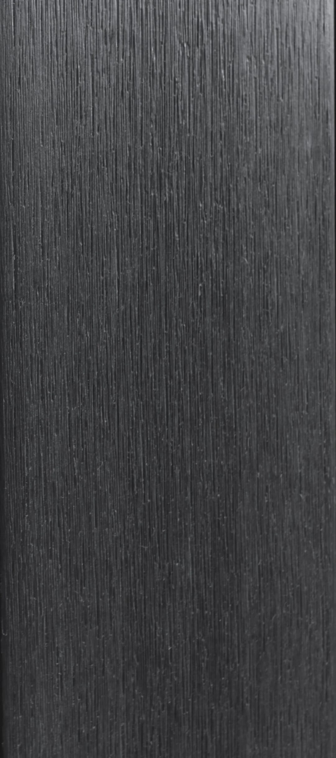 UltraDeck LuxNature composite decking board face in Charcoal, a near-black grey with a sanded matt grain, shown as a full-length swatch strip