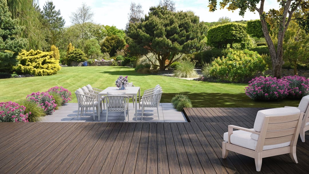 Low Bali deck with a white armchair overlooking a paved dining area, lawn and flowering garden beds