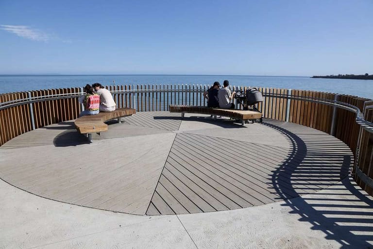 Circular seaside lookout platform decked in ModWood Marina boards, with a curved timber railing and bench seats