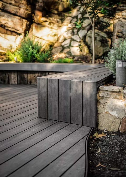 Ekodeck Flame Fighter Shadow Grey deck with a built-in bench seat, set against a sandstone rock face
