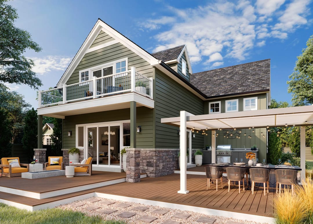 Tan Lineage Jasper deck behind a green two-storey house, with a white pergola over dining and lounge areas