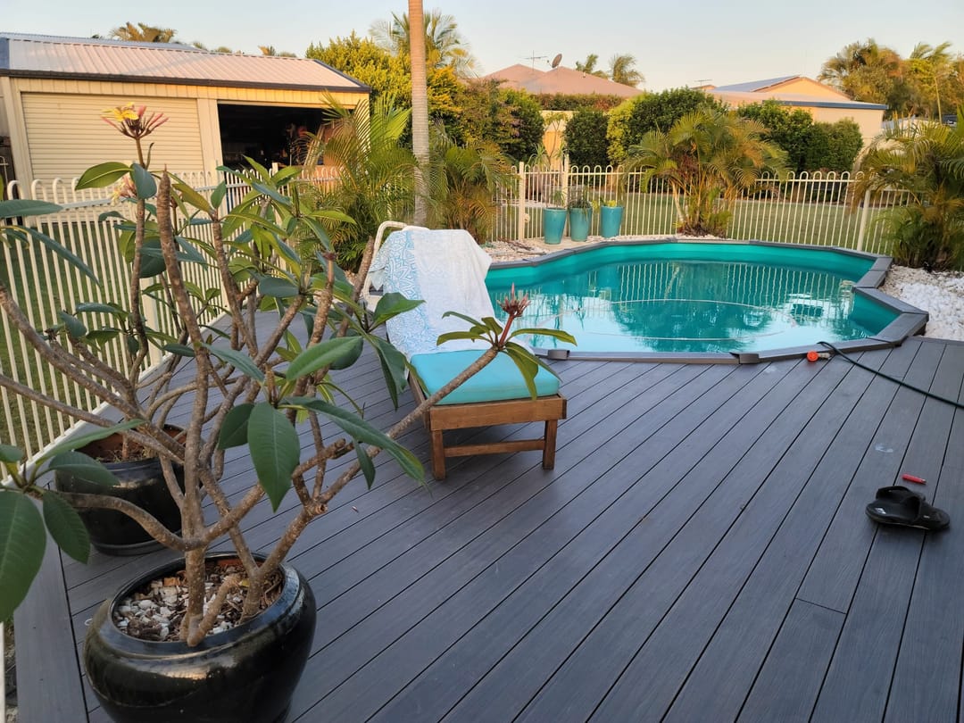 Dark Sun Decking Elite Slate Grey deck around an above-ground pool, with a potted frangipani and a sun lounger