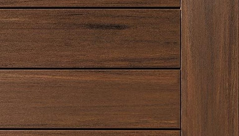 Close-up of TimberTech Vintage decking in Mahogany, a reddish brown with dark streaks, boards meeting a fascia board