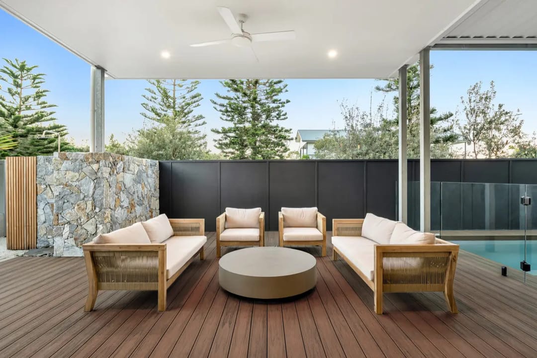 Colour visualisation of a covered alfresco deck in COEN Chocolate, a dark reddish-brown, with outdoor lounges and a stone feature wall