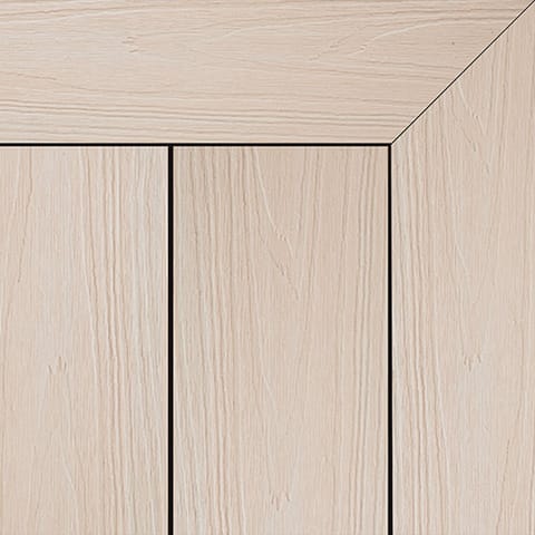 Close-up of Brite HD PRO composite deck boards in Coastal Sand, a pale cream woodgrain, with a mitred picture-frame corner