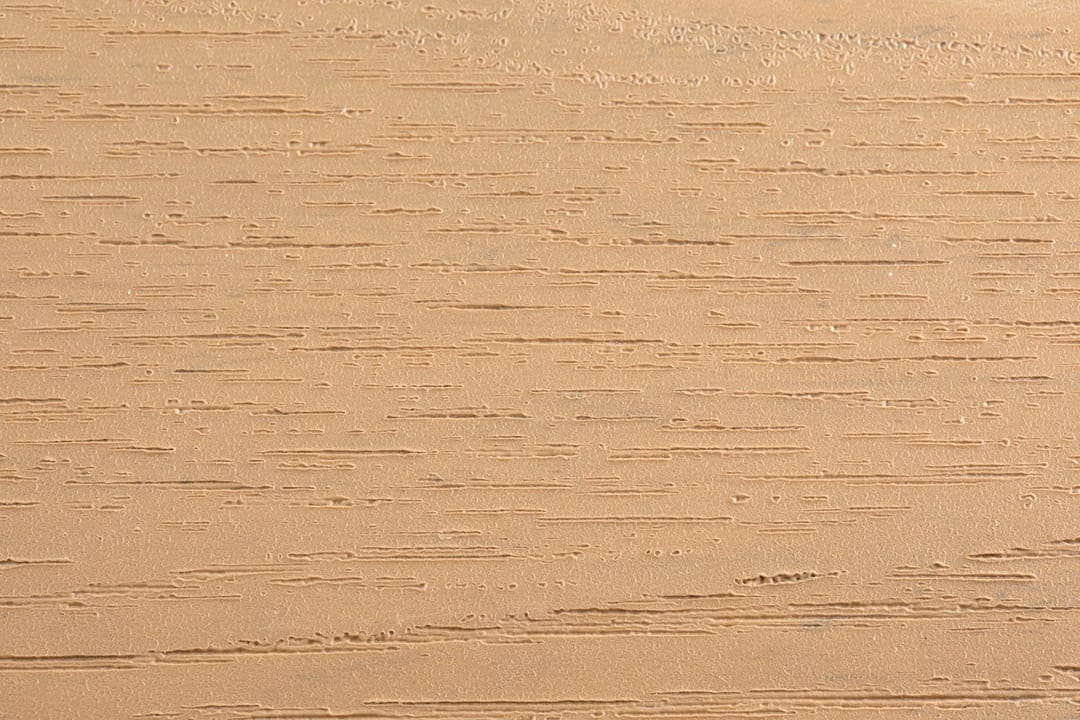 Close-up of an Evertex Supreme Max Caramel board surface showing its embossed wood-grain texture in warm caramel