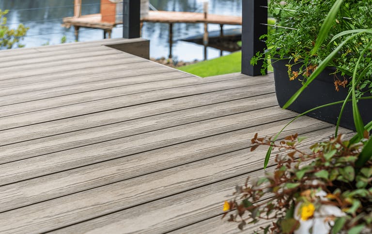 Grey Brite NextGen Titanium waterfront deck with potted plants looking over a canal and jetty