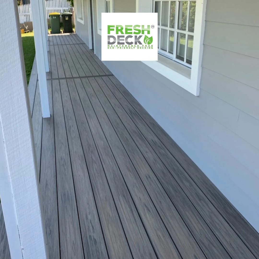 Long grey FreshDeck composite verandah deck running along a weatherboard house beside the front windows