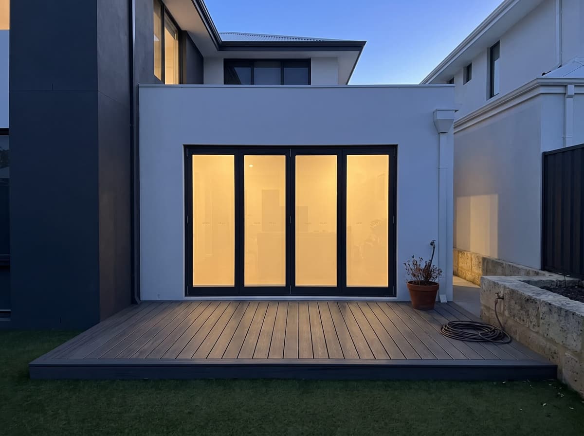 AI picture of the same house with a deck in Ekodeck Classic, Greystone, at dusk, with the boards running out from the house